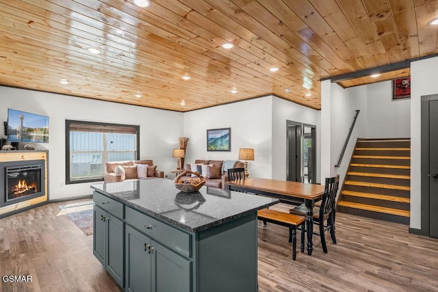 1105 Center St # 3, Sevierville, TN 37862 - kitchen featuring wooden ceiling, a kitchen island, wood finished floors, a glass covered fireplace, and dark stone countertops