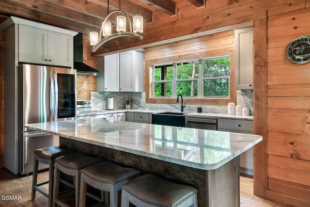 4427 Stackstone Rd, Sevierville, TN 37862 - kitchen with stainless steel appliances, a sink, wall chimney range hood, wooden walls, and light stone countertops