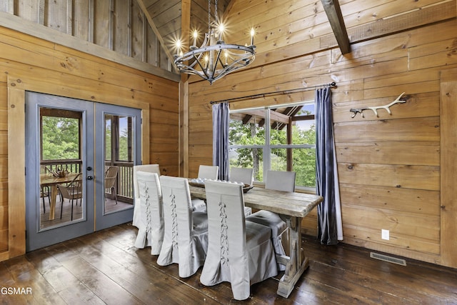 4427 Stackstone Rd, Sevierville, TN 37862 - dining space featuring french doors, a chandelier, dark wood-style floors, vaulted ceiling, and wood walls