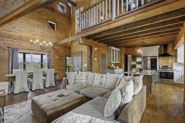 4427 Stackstone Rd, Sevierville, TN 37862 - living area with a chandelier, wood walls, beamed ceiling, light wood-style flooring, and a high ceiling