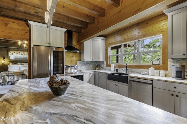 4427 Stackstone Rd, Sevierville, TN 37862 - kitchen with appliances with stainless steel finishes, wall chimney range hood, wooden ceiling with exposed beams, a sink, and light stone counters