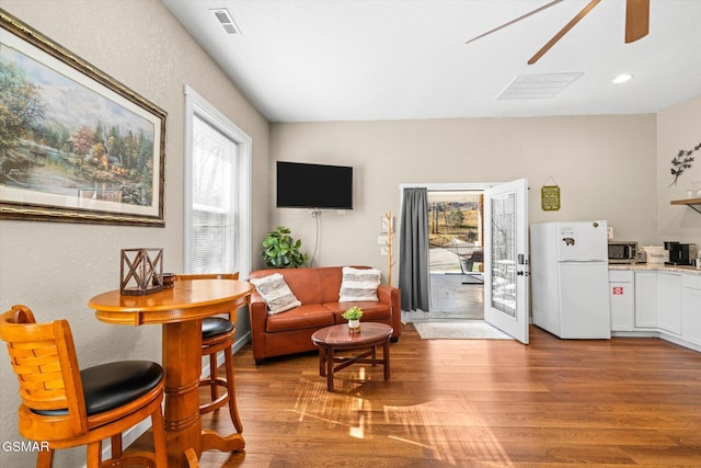 living room featuring recessed lighting, light wood-type flooring, visible vents, and a ceiling fan