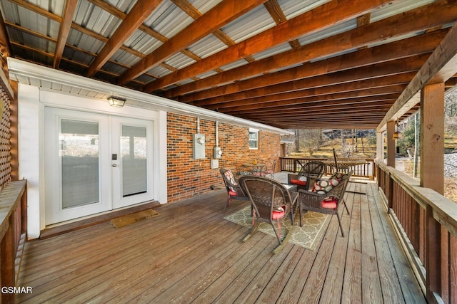 wooden terrace with outdoor dining space and french doors