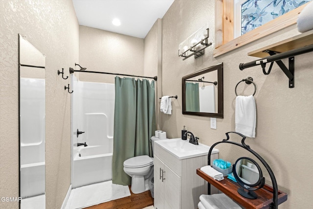 full bath featuring vanity, toilet, shower / tub combo with curtain, and a textured wall