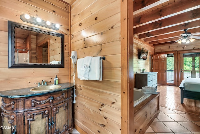 bathroom featuring beam ceiling, wooden walls, tile patterned flooring, and a bathtub