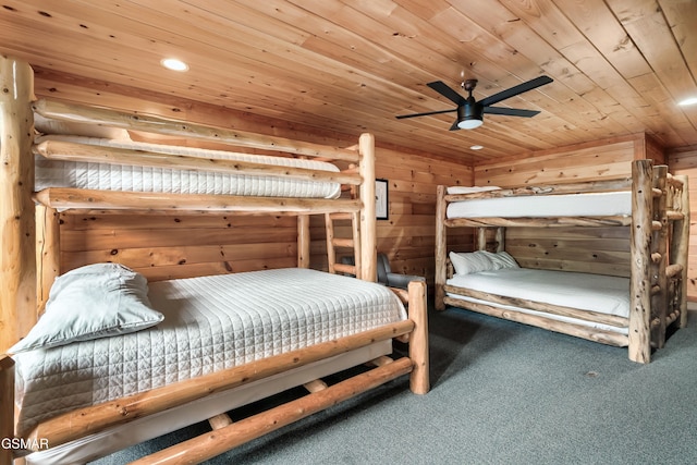 carpeted bedroom featuring ceiling fan, wood walls, and wood ceiling