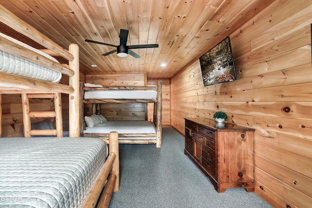 bedroom with dark colored carpet, wooden walls, and wooden ceiling