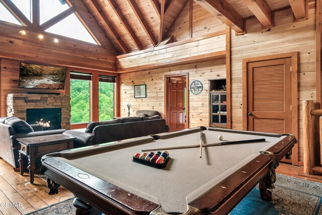 rec room featuring wood ceiling, wooden walls, beamed ceiling, a stone fireplace, and pool table