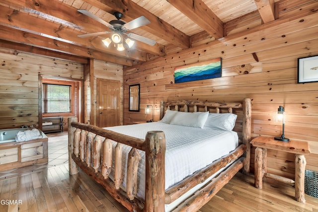 bedroom featuring beamed ceiling, wood-type flooring, and wooden walls