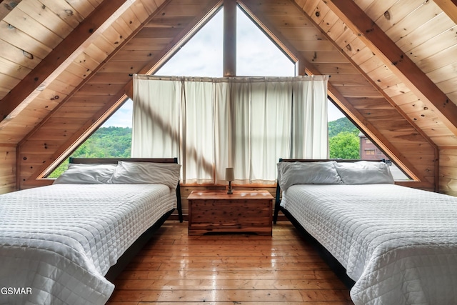 bedroom with vaulted ceiling with beams, wood walls, and wooden ceiling