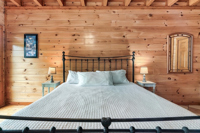 unfurnished bedroom featuring wood walls and beamed ceiling