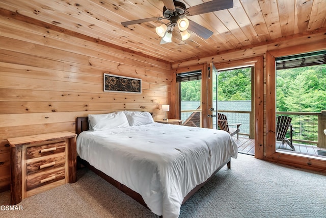 carpeted bedroom with ceiling fan, access to exterior, wooden ceiling, and wooden walls