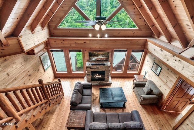 living room featuring high vaulted ceiling, wood ceiling, and wooden walls