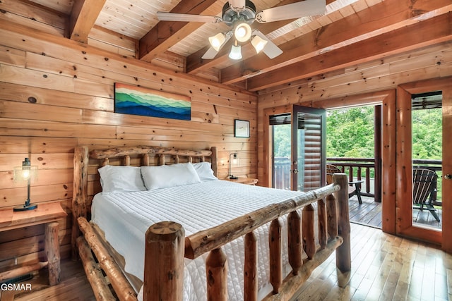 bedroom with wooden walls, hardwood / wood-style flooring, access to exterior, beamed ceiling, and wood ceiling