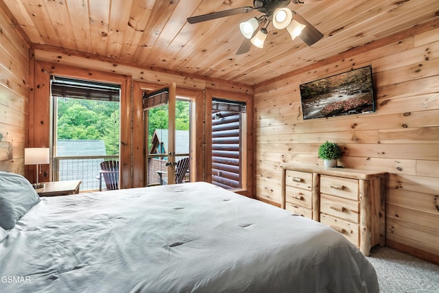 bedroom with ceiling fan, wooden ceiling, wood walls, carpet floors, and access to outside