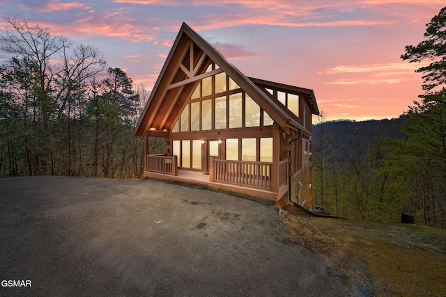 property exterior at dusk featuring covered porch