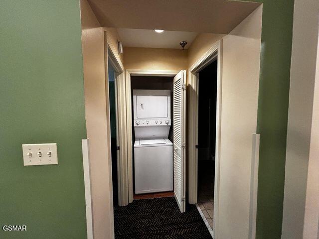 hall with stacked washer / dryer