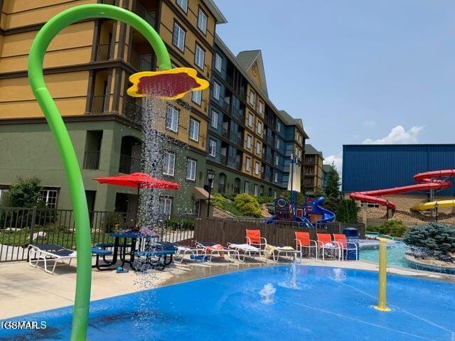 view of pool with fence and playground community