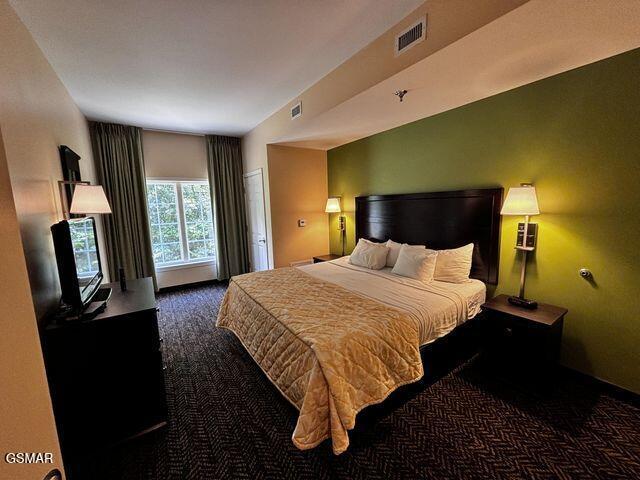 bedroom featuring visible vents and dark colored carpet