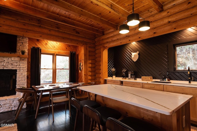 1317 Old Knoxville Hwy, Sevierville, TN 37876 - kitchen with a sink, dark wood-style floors, wooden ceiling with exposed beams, log walls, and a kitchen island