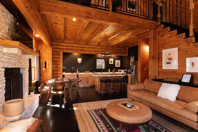 1317 Old Knoxville Hwy, Sevierville, TN 37876 - living area featuring dark wood-style flooring, wood walls, a stone fireplace, and wooden ceiling with exposed beams