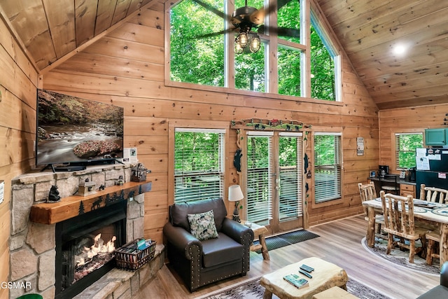 living area featuring wood walls, wood ceiling, ceiling fan, and wood finished floors