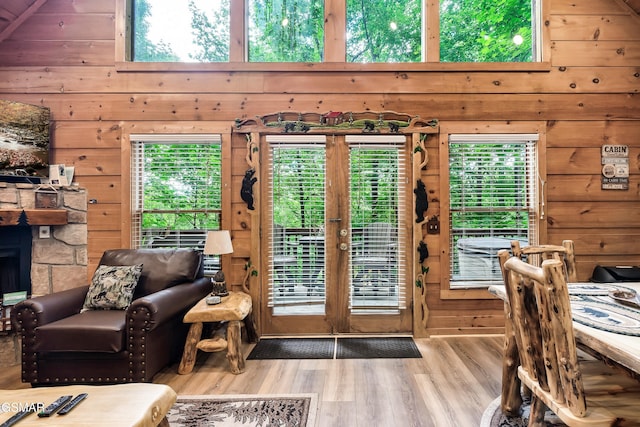 entryway featuring wooden walls, plenty of natural light, and wood finished floors
