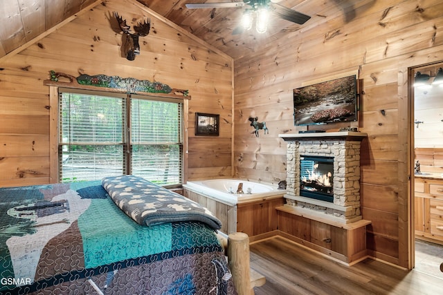 bedroom featuring vaulted ceiling, wood walls, and wood finished floors