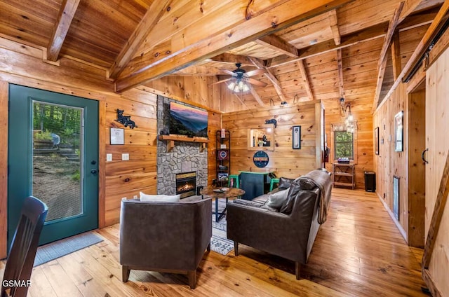 3110 Cove Creek Way, Sevierville, TN 37862 - living room with wood ceiling, light wood-style floors, wooden walls, ceiling fan, and a fireplace