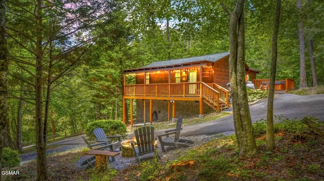 3110 Cove Creek Way, Sevierville, TN 37862 - back of house featuring a wooded view, asphalt driveway, stairway, an outdoor fire pit, and a wooden deck