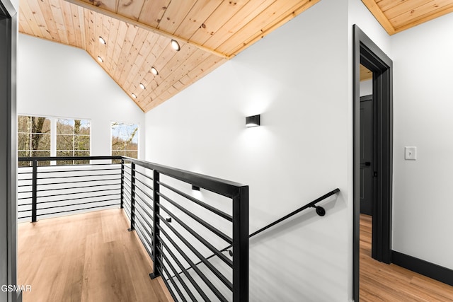 corridor featuring high vaulted ceiling, light wood-type flooring, and wood ceiling