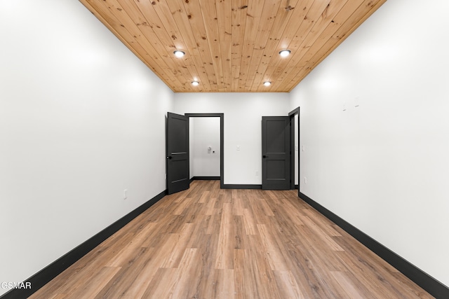 empty room with wood ceiling and light hardwood / wood-style floors