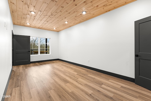 unfurnished room with light wood-type flooring and wooden ceiling