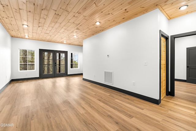 empty room featuring wood ceiling, plenty of natural light, and light wood-type flooring