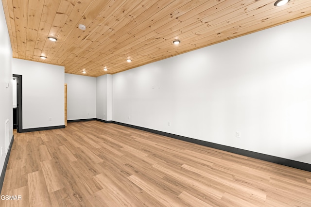 spare room featuring light wood-type flooring and wood ceiling