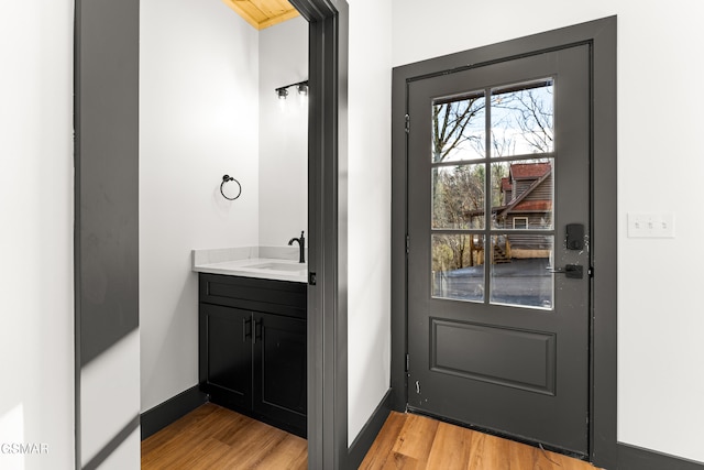 doorway featuring sink and light wood-type flooring