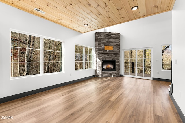 unfurnished living room featuring high vaulted ceiling, hardwood / wood-style floors, a fireplace, and wood ceiling