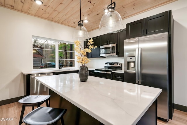 kitchen with sink, wood ceiling, pendant lighting, stainless steel appliances, and light stone countertops