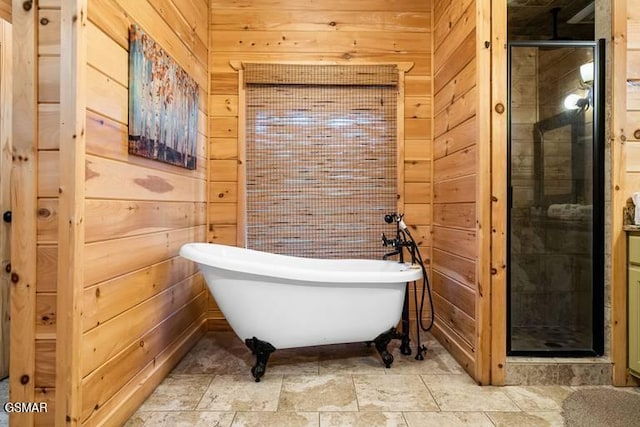 bathroom featuring wooden walls, a stall shower, and a freestanding bath