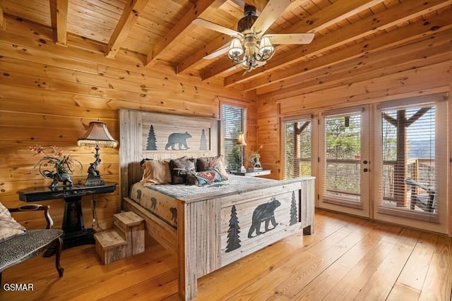 bedroom with access to outside, light wood finished floors, wood ceiling, and wood walls