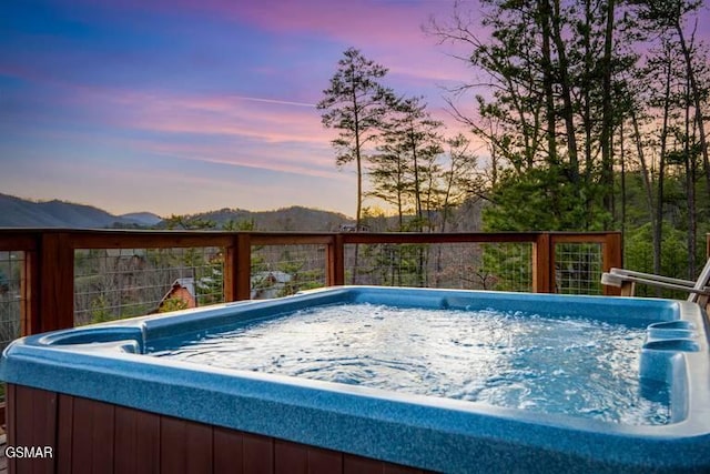 view of swimming pool with a mountain view and a hot tub