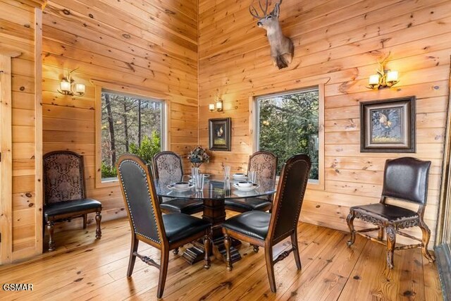 dining room with light wood-type flooring and wooden walls