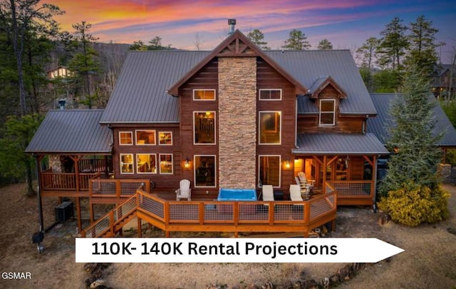 back of property at dusk with an outdoor living space, metal roof, and a deck