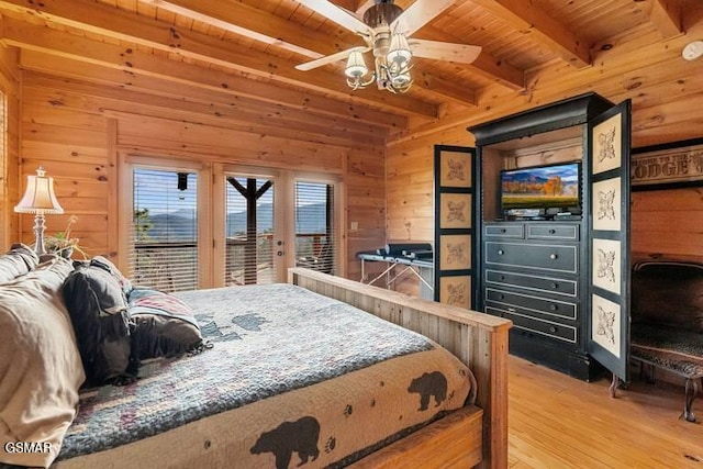 bedroom with access to outside, wood ceiling, light wood-type flooring, and wood walls