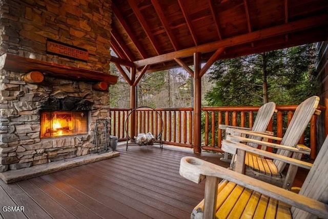 deck with an outdoor stone fireplace