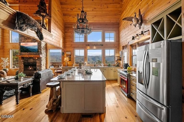 kitchen with light wood finished floors, open floor plan, stainless steel appliances, and high vaulted ceiling