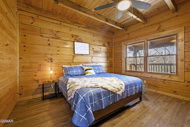 bedroom with ceiling fan, wood ceiling, wood walls, and beamed ceiling