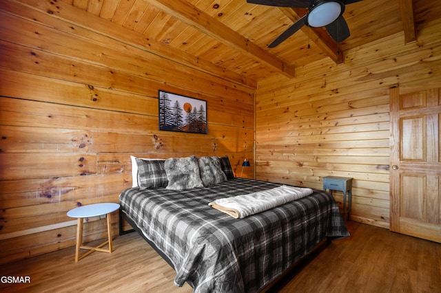 bedroom with beam ceiling, ceiling fan, wood walls, and wooden ceiling