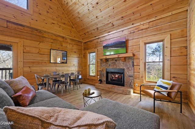 living room featuring light wood-type flooring, wooden ceiling, a fireplace, and high vaulted ceiling