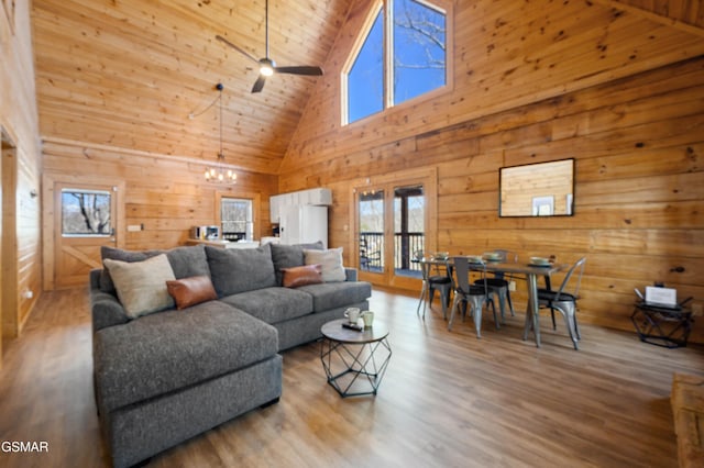 living room featuring beamed ceiling, hardwood / wood-style flooring, wood ceiling, high vaulted ceiling, and ceiling fan with notable chandelier